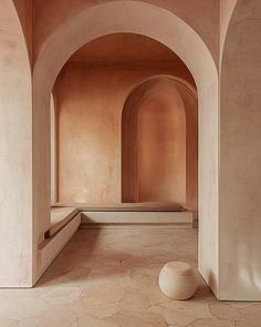 an empty room with arches and a ball on the floor