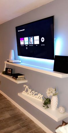 a flat screen tv mounted on the side of a wall next to a book shelf