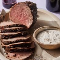 a plate with sliced meat and dip on it