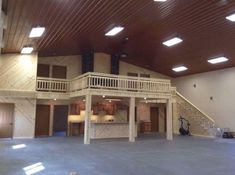 the inside of a large building with two people standing in front of an open floor plan