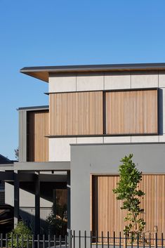 a large building with wooden slats on the front and side walls, next to a fence