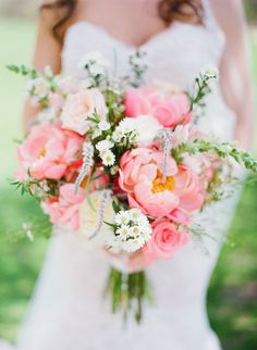 a bride holding a bouquet of pink and white flowers