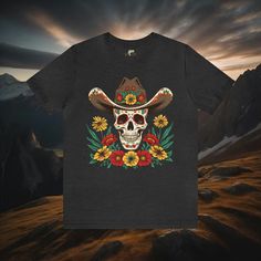 Saddle up and get ready to ride in our Cowboy Skull and Wildflowers Unisex Tee. This jersey short sleeve tee features a striking cowboy skull surrounded by vibrant wildflowers, paying homage to folk art design. Perfect for any cowgirl or cowboy, this tee seamlessly combines unique style with comfort, making it a must-have addition to your wardrobe. Giddy up and add a touch of Western flair to your look today. #15 Folk Art Classic unisex jersey short sleeve tee fits like a well-loved favorite. So Day Of The Dead Skull Print Short Sleeve T-shirt, Day Of The Dead Skull Print T-shirt, Black Short Sleeve T-shirt For Day Of The Dead, Cowboy Skull, Folk Art Design, Skull Tee, Western Chic, The Wild West, Arte Popular