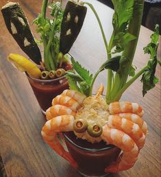 two small pots filled with food on top of a wooden table