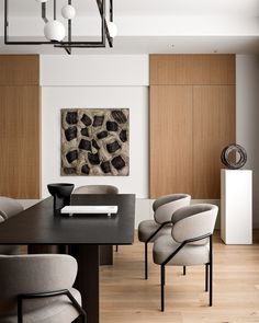 a dining room table with chairs and a painting on the wall in the back ground