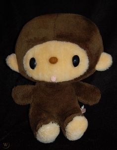 a teddy bear with a monkey costume on it's head and eyes, sitting in front of a black background