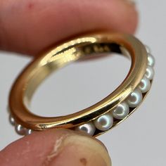 This gorgeous pearl eternity ring adds a touch of elegance and sophistication to any ring stack! 25 seed pearls, likely Akoya, encircles a 14k yellow gold band. She's got a beautiful height and thickness to her (about 3.5 mm width x 2.5mm rise), which is why she's perfect for stacking. Hallmarked with B&F 14K (Baden & Foss, I believe). I've not been able to find other pearl eternity rings set like this, which makes her extra special.  Size US 6.25,  Weight 4.11 grams Material 14k yellow gold Elegant Wedding Rings With Pearl Chain, Elegant Pearl Stackable Rings For Anniversary, Elegant Pearl Chain Rings For Wedding, Elegant Pearl Stackable Rings As Promise Ring, Elegant Pearl Stackable Promise Rings, Elegant Stackable Pearl Ring In Yellow Gold, Elegant Pearl Stackable Rings For Promise, Elegant Pearl Stackable Rings, Elegant Round Pearl Stackable Rings