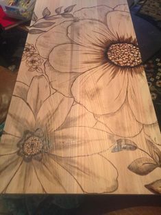 a wooden table with flowers painted on the top and bottom part, along with other woodworking supplies