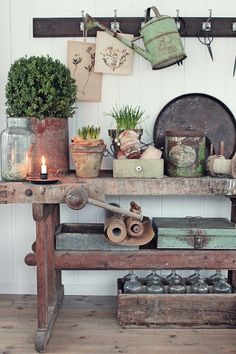 an old wooden table with pots and plants on it