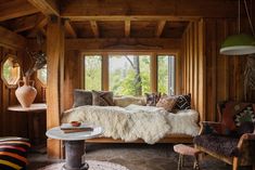 a living room filled with furniture next to a window covered in blankets and rugs