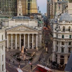 an aerial view of the city with tall buildings and cars driving down it's street