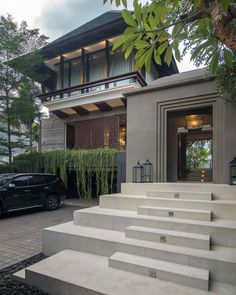 a car is parked in front of a house with steps leading up to the entrance