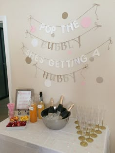 a table topped with champagne glasses next to a sign that says pop the bubbly she's getting a habby