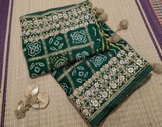 A Lovely Green Pure Gaji Silk Bandhej Gota Embroidered Saree in Gharchola Pattern. The saree is adorned with intricate gota patti handwork which makes it all the more a perfect choice for occasion wear. Its a fusion of karigari from Gujarat and Rajasthan. We must say, a truely heirloom piece. The Bandhej is tye and dyed in Gujarat. Then the karigars of Rajasthan have worked their magic with the gota embroidery. So its takes about a couple of months for a single saree to be ready. Additional Information Color : Green Fabric: Pure Gaji Silk Blouse Piece: Included (Refer Last Pic in the Listing) Since this product is handwoven, there might be slight irregularities. But doesn't that add to the singular charm of a handloom beauty? Gota Embroidery, Embroidered Saree, Green Fabric, Blouse Piece, Occasion Wear, Favorite Outfit, Hand Weaving, Accessory Gift, Saree