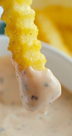 a close up of a spoon with some food in it and chips on the side