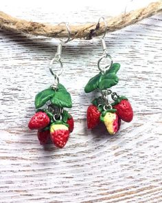 Indulge in the whimsical charm of nature with these hand-sculpted miniature strawberry earrings crafted from polymer clay. Inspired by the beauty of strawberries, each delicate cluster dangles approximately 1-1/8 inches below silver-plated earring hooks, adding a playful touch to any ensemble. Lightweight and enjoyable to wear, these earrings are the perfect accessory for adding a dash of fruity flair to your look. Whether for yourself or as a delightful gift, these earrings are sure to bring joy, especially to a young girl enamored by nature's wonders. Handmade Polymer Clay Jewelry For Birthday, Polymer Clay Dangle Earrings For Birthday, Dangle Polymer Clay Jewelry For Birthday, Dangle Polymer Clay Earrings For Birthday, Birthday Polymer Clay Dangle Earrings, Birthday Dangle Earrings Made Of Polymer Clay, Resin Dangle Jewelry For Birthday, Birthday Resin Dangle Jewelry, Sweet Handmade Polymer Clay Jewelry