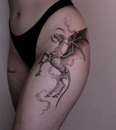 a woman with a dragon tattoo on her thigh