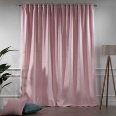 a pink curtain hanging on the side of a wall next to a potted plant