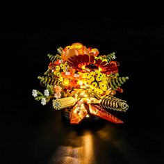 a vase filled with lots of different types of flowers on top of a black table