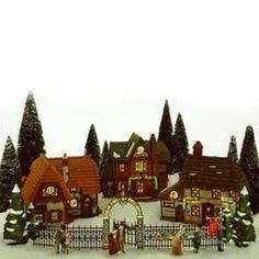 a christmas village with houses and trees in the snow