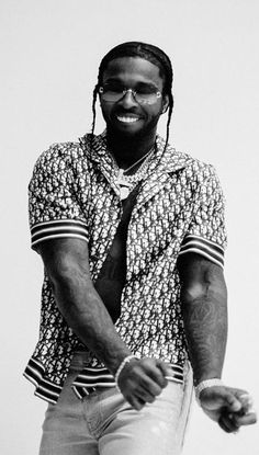 a man with dreadlocks standing in front of a white wall