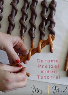 two hands are decorating chocolate pretzels on a sheet of paper with the words caramel pretzel video tutor