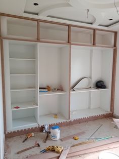 an unfinished room with shelves and tools on the floor