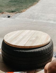 a wooden table sitting on top of a pile of tires