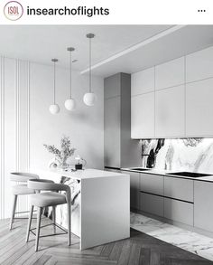 a white kitchen with marble counter tops and stools next to the island in front of it