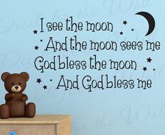 a teddy bear sitting on top of a dresser next to a wall decal that says i see the moon and the moon sees me