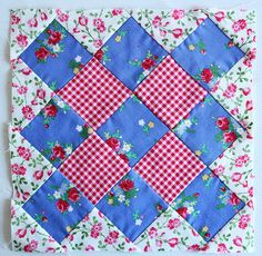 a blue and white quilt with red flowers on the front, and pink roses on the back