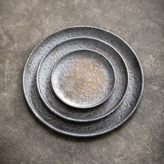 three metal plates stacked on top of each other in the shape of an oval, with rusted edges