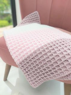 a pink chair with a knitted pillow on it