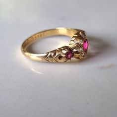 18ct ruby and diamond antique ring ruby trilogy ring with old cut diamond halo rubies measuring at  center- side stones- hallmark- crown  750 (English 18Ct hallmark) wheatsheaf (chester hallmark- worn but legible)  'X' (cannot find year, likely to be pre 1900) Item will be presented in a leatherette ring box Antique Ruby Ring, Ruby And Diamond Ring, Trilogy Ring, Ring Ruby, Antique Diamond Rings, Antique Ring, Ruby Ring, Diamond Halo, Antique Rings