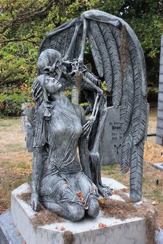 a statue of an angel holding a skeleton