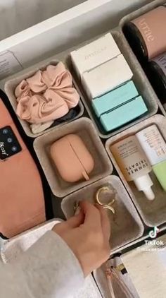 a woman is holding an open case with various items in it and she has her hand on the lid