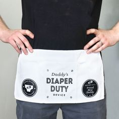 a man holding an apron with the words daddy's diaper duty on it