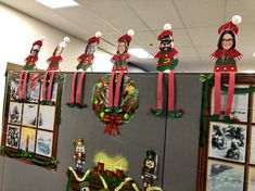 christmas decorations are hanging on the wall in an office cubicle decorated with red and green ribbons