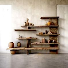 some shelves with vases and other items on them in a room that looks like it is made out of wood