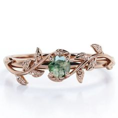 a gold ring with an oval green stone in the center and leaves on each side