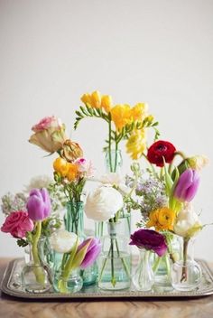 two pictures of vases filled with flowers on top of a wooden table next to each other