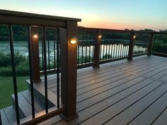 a wooden deck with lights on it at sunset