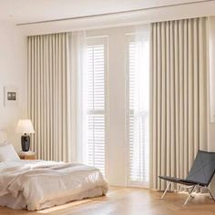 a bedroom with white walls and wooden floors