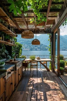 an outdoor kitchen with wooden flooring and lots of greenery hanging from the ceiling