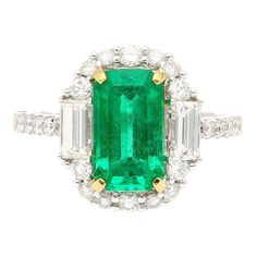 2.22 carat natural Colombian Emerald and Diamond Ring. Centering a lustrous emerald-cut emerald, measuring 10.3 x 6 MM, a desirable elongated shape that gracefully enhances the length of the finger.   The emerald is flanked by two baguette-cut diamonds, totaling 0.50 carats, and adorned by 24 round brilliant-cut diamonds, totaling 0.60 carats, creating a harmonious symphony of step and brilliant cuts. Set in smooth 18k white gold.   Ideal as an engagement ring or cocktail ring.   Ring Details: - Diamond Chandelier Earrings, Diamond Chandelier, Statement Rings Diamond, Platinum Diamond Rings, Colombian Emeralds, Diamond Cocktail Rings, Diamond Hoop Earrings, Platinum Ring, Diamond Drops