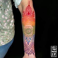 a woman's arm with a colorful tattoo design on the left side of her arm