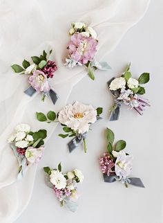 the bridal bouquets are laid out on top of the white cloth, and ready to be put in