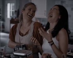 two women laughing in the kitchen together