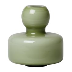 a green vase sitting on top of a white table