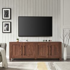 a large flat screen tv mounted to the side of a wooden cabinet in a living room